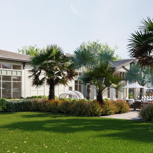 a building near a pool with lush landscaping and palm trees