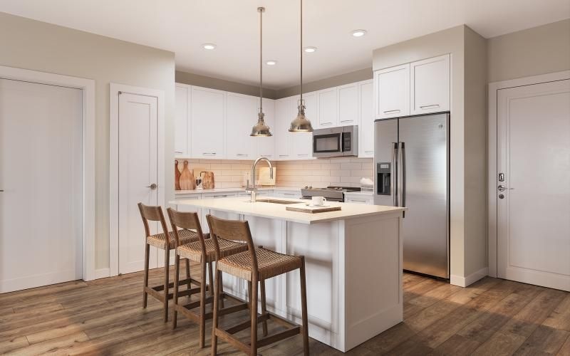 a spacious kitchen with stainless steel appliances, an island, and pendant lighting